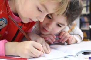 deux enfants en train d'écrire et dessiner, illustre le concours Librius 2022